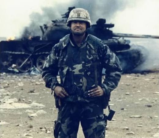 Ennis in front of tank destroyed in the Gulf War.
